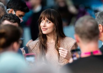 Dakota Johnson at the premiere in a “Gucci” golden dress with gems and pearls